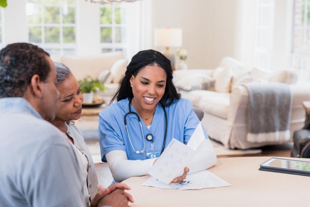 Two people looking at a book Description automatically generated with low confidence